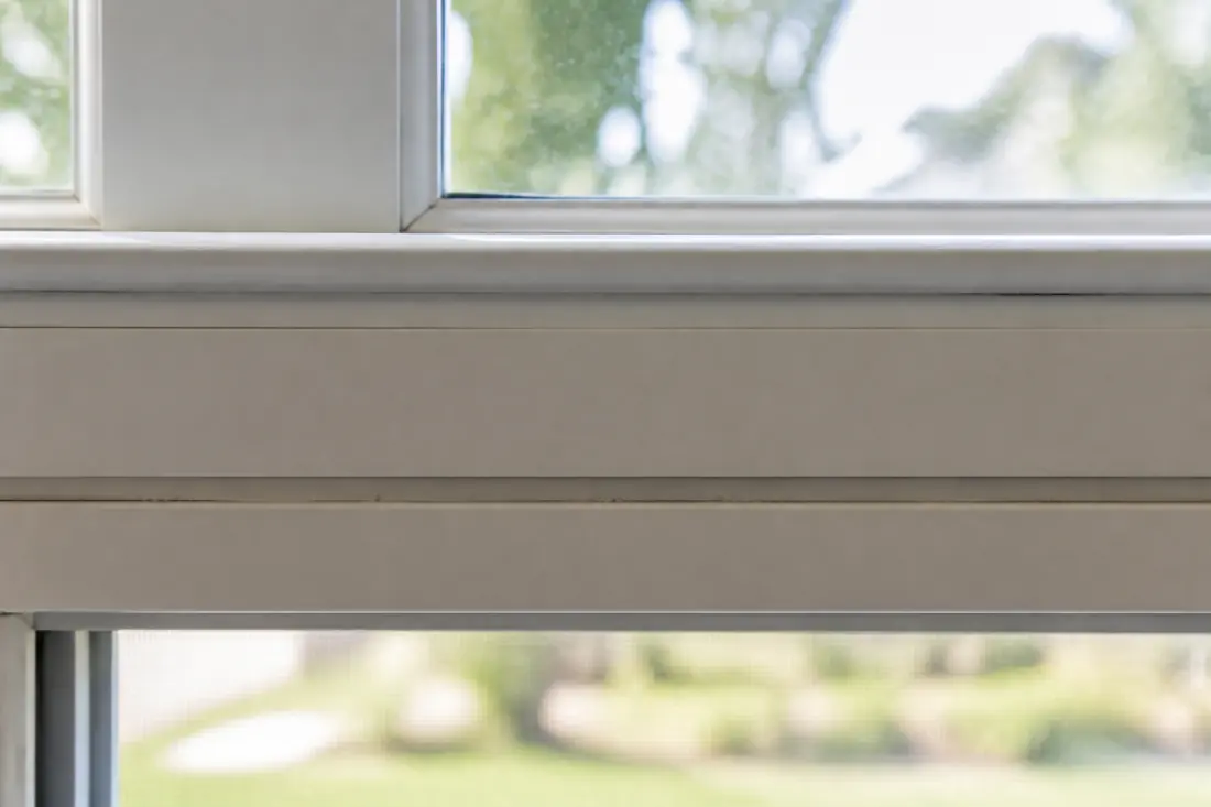 The meeting rail of a single-hung window with the lower sash raised