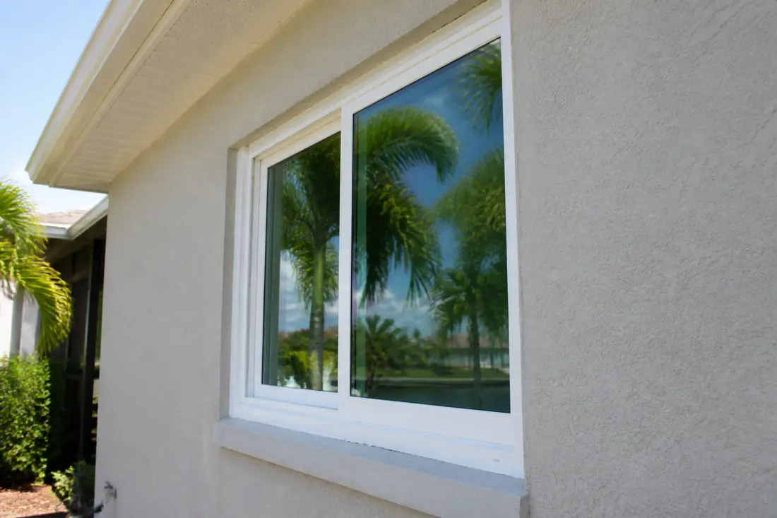 A newly installed impact window set in a masonry opening, seen from outside at an angle
